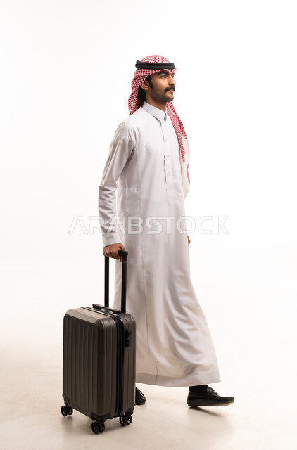 Saudi Man Walking with Suitcase in Traditional Thobe
