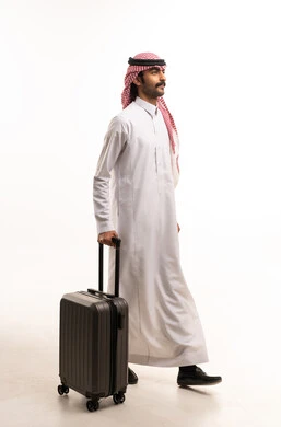 رجل سعودي بالزي التقليدي يحمل حقيبة سفر