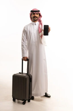 رجل سعودي مع حقيبة سفر وهاتف ذكي خلفية بيضاء