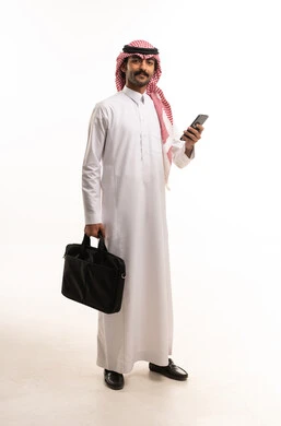 رجل أعمال سعودي يحمل هاتف ذكي وحقيبة لابتوب