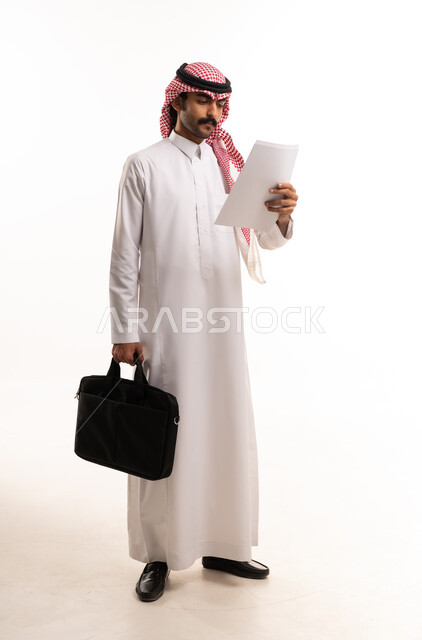 رجل أعمال سعودي بالثوب التقليدي يحمل حقيبة أوراق