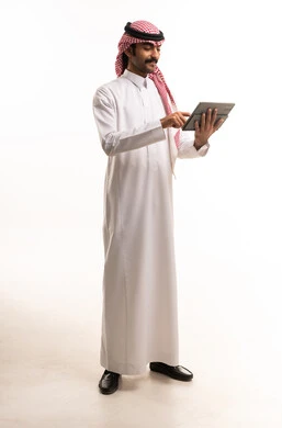 Saudi Man in Traditional Attire Using Digital Tablet