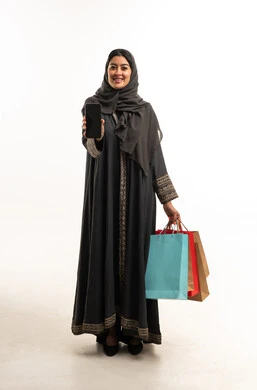 Saudi Woman with Shopping Bags and Smartphone White Background