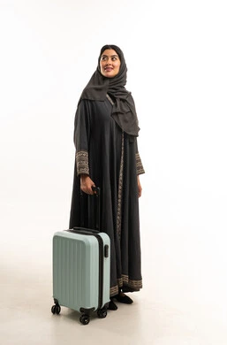 Saudi Woman Wearing Abaya Standing with Blue Suitcase