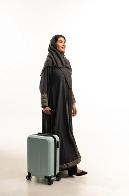 امرأة سعودية مسافرة مع حقيبة سفر في الاستوديو