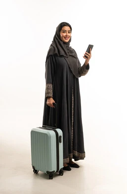 امرأة سعودية مع حقيبة سفر وهاتف ذكي خلفية بيضاء