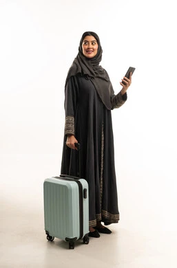 امرأة عربية مسافرة مع حقيبة سفر وهاتف ذكي