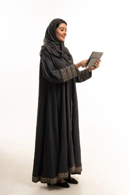 Saudi Woman in Black Abaya Using Digital Tablet in Studio