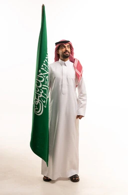 Saudi Man in Traditional Dress Holding Saudi Flag