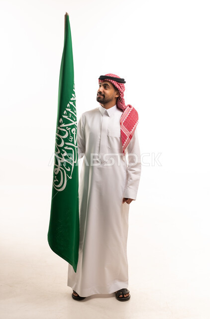 رجل سعودي يحمل علم المملكة العربية السعودية