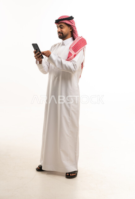 رجل سعودي يستخدم الهاتف الذكي بخلفية بيضاء