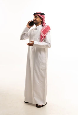 رجل سعودي بالثوب التقليدي يستخدم الهاتف الذكي