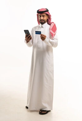 رجل سعودي يحمل بطاقة ائتمان وهاتف ذكي خلفية بيضاء