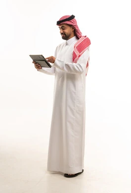 Saudi Man in Traditional Thobe Using Tablet