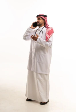 طبيب سعودي يتحدث بالهاتف المحمول في استوديو بخلفية بيضاء