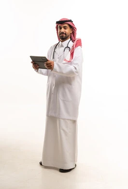طبيب سعودي يحمل جهاز لوحي بخلفية بيضاء