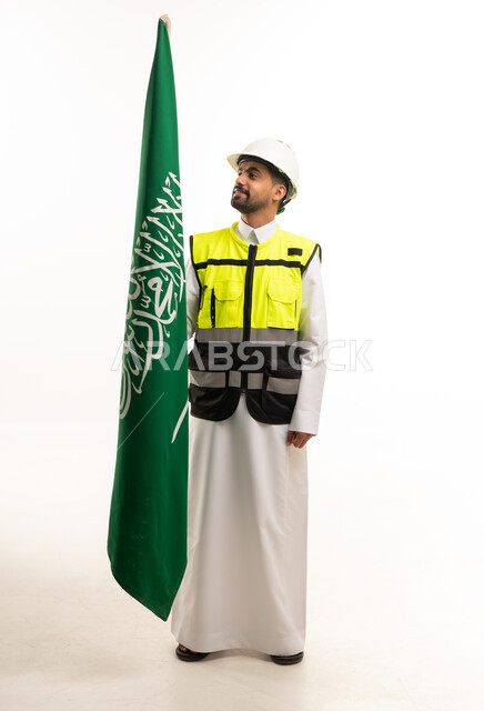 مهندس سعودي بالثوب يمسك علم المملكة