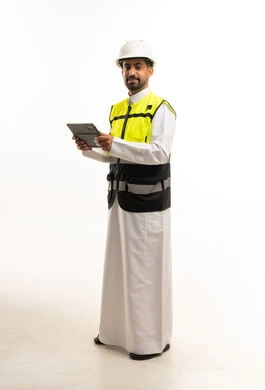 مهندس سعودي يرتدي معدات السلامة ويحمل جهاز لوحي
