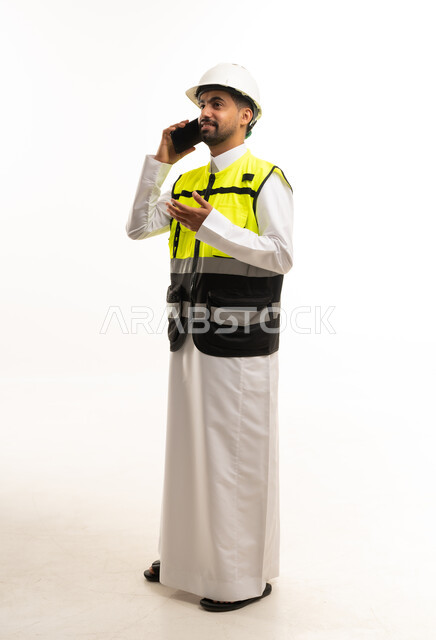 مهندس سعودي بمعدات السلامة يتحدث عبر الهاتف