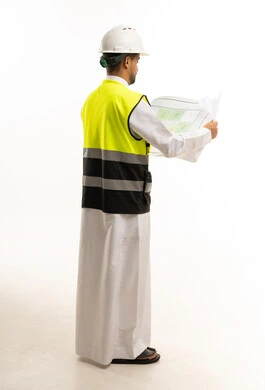 مهندس سعودي يرتدي سترة السلامة ويمسك مخططات بناء