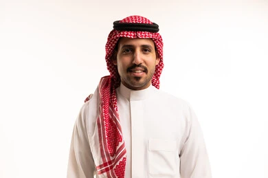 رجل سعودي بالزي التقليدي أمام خلفية بيضاء