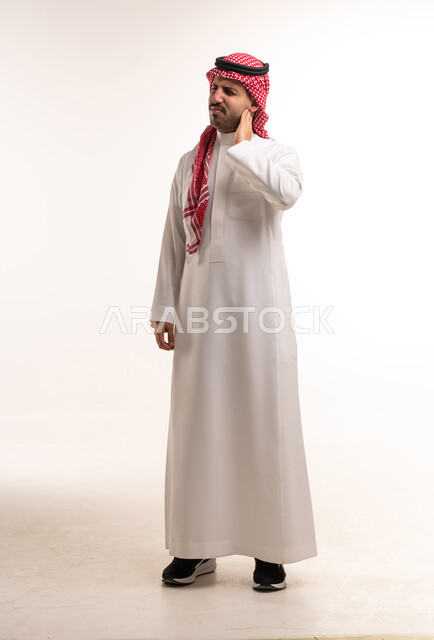رجل سعودي بالثوب التقليدي يعاني من ألم الرقبة
