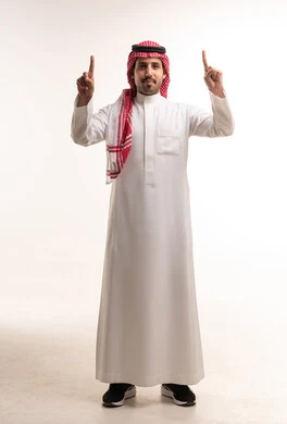 رجل سعودي بالثوب التقليدي يشير للأعلى بخلفية بيضاء