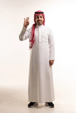 رجل سعودي بالزي التقليدي يؤدي علامة التمام بيده