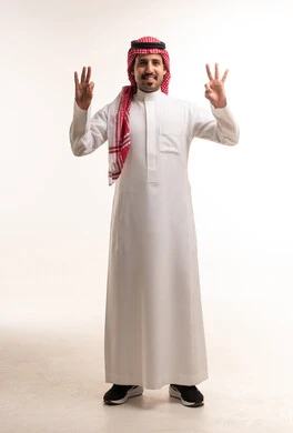 رجل سعودي بالزي التقليدي يقوم بحركات يدوية في استوديو