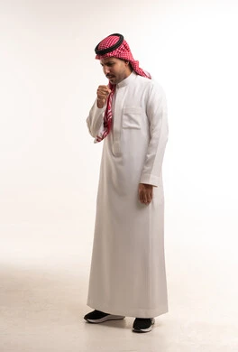 رجل سعودي بالثوب التقليدي يسعل في استوديو