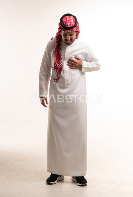 رجل سعودي بالثوب يمسك صدره من الألم