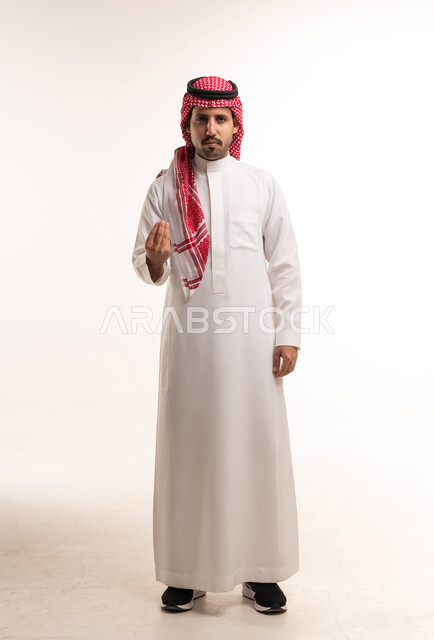 رجل سعودي بالثوب التقليدي يؤدي حركة اليد في استوديو