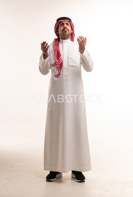 Saudi Man in Traditional Thobe Praying on White Background