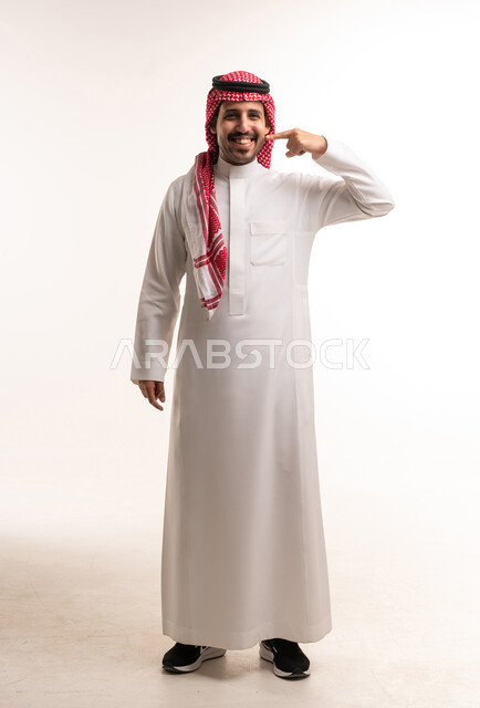 Saudi Man in Traditional Thobe Pointing at Cheek