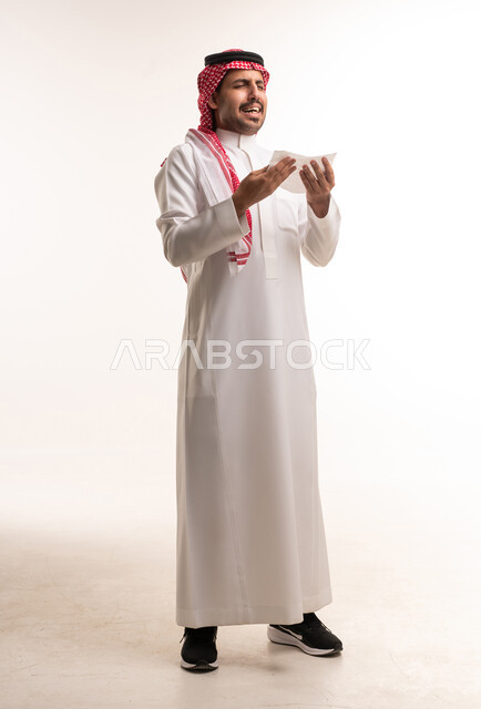 رجل سعودي يرتدي الثوب التقليدي يعطس حاملاً منديلاً