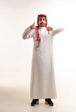 رجل سعودي يرفع إبهامه للأعلى وللأسفل في استوديو