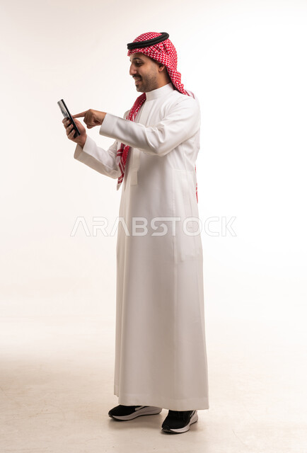 Saudi Man in Thobe Using Smartphone on White Background