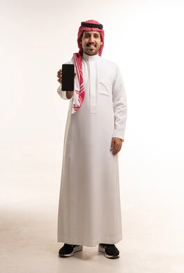 رجل سعودي بالزي التقليدي يحمل هاتف ذكي في الاستوديو