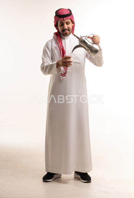 رجل سعودي يسكب القهوة العربية التقليدية في الاستوديو
