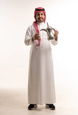 Saudi Man in Traditional Dress Pouring Arabic Coffee