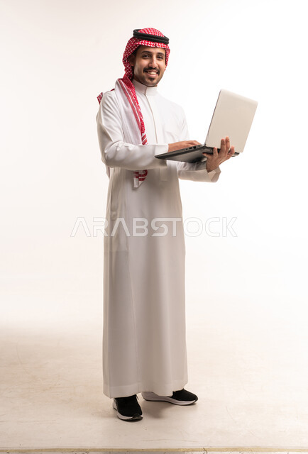 رجل سعودي مع كمبيوتر محمول بخلفية بيضاء