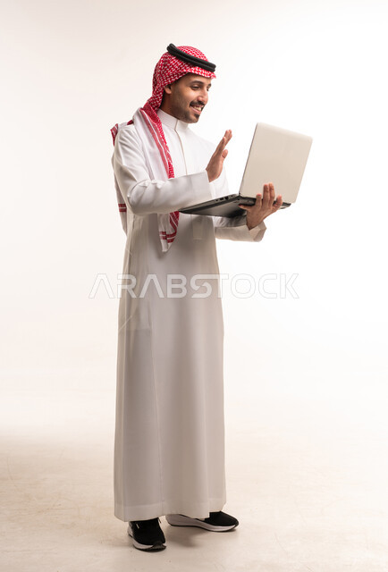 Saudi Man in Traditional Thobe Using Laptop