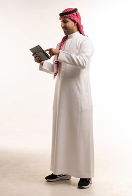 Saudi Man in Traditional Thobe Using Digital Tablet