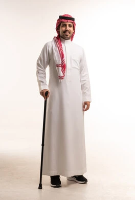 رجل سعودي بالزي التقليدي مع عصا للمشي