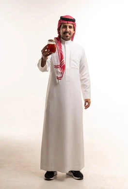 Saudi Man in Traditional Thobe Holding Honey Jar