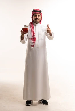 Saudi Man Holding Honey Jar with Thumbs Up Gesture