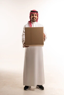 رجل سعودي يحمل صندوق شحن كرتوني في الاستوديو