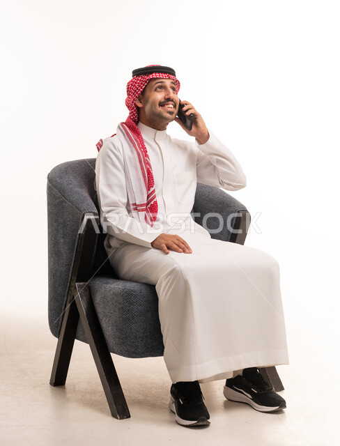 رجل سعودي بالزي التقليدي يتحدث عبر الهاتف الجوال