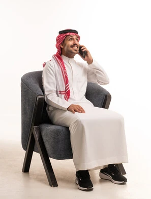 رجل سعودي بالزي التقليدي يتحدث عبر الهاتف الجوال