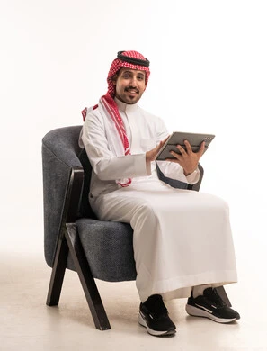 رجل سعودي يستخدم جهاز لوحي بخلفية بيضاء